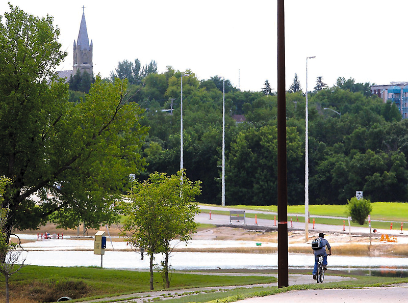 Colin Corneau/Brandon Sun
A cyclist makes his way along a portion of the pedestrian walkway recently resurfaced from receding floodwaters along First Street North.