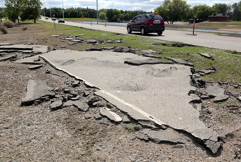 Colin Corneau/Brandon Sun
A section of asphalt road surface lies in the ditch along First Street North near Dinsdale Park on Monday, after being lifted from its place by floodwaters over the past month.