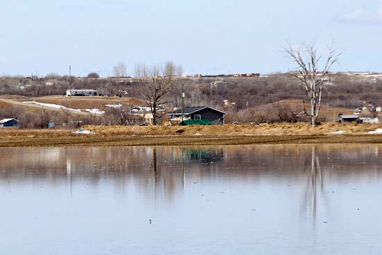 Ian Froese/The Brandon Sun
Water from the Assiniboine River approaches a Sioux Valley Dakota Nation home that has a dike surrounding the property on Monday.