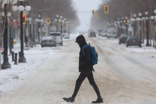 Tim Smith/The Brandon Sun
A pedestrian crosses Rosser Avenue on Thursday after the April blizzard had mostly ended. David Docherty said although the snowstorm may not have been as bad as initially predicted, it was important for Brandon University to take the forecast seriously in order to protect students and staff from what could’ve been.