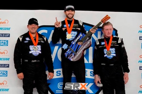 Chase Elliott, center, holds his winner's guitar after winning the SRX Series auto race Saturday, July 17, 2021, in Nashville, Tenn. Tony Stewart, left, finished second, and Bill Elliott, right, finished third. (AP Photo/Mark Humphrey)