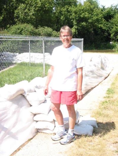 Andrea Geary
RM of Cartier public information officer Carmen Asu stands next to the sandbag dike surrounding her home on Ferry Road.