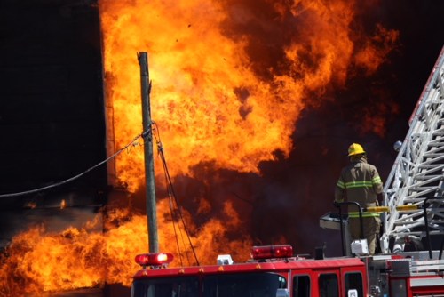 Matt Goerzen/The Brandon Sun
A Brandon firefighter is seen against a wall of flame that destroyed the Christie's Office Plus building on Pacific Avenue on Saturday afternoon.