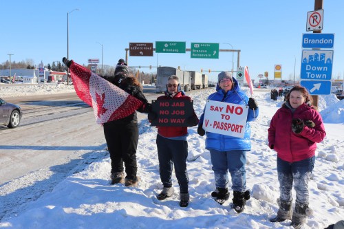 Bystanders watch a convoy of trucks pass through Brandon along the Trans Canada Highway, bound for Ottawa as part of a protest against pandemic restrictions and vaccine mandates, on Tuesday morning. (Kyle Darbyson/The Brandon Sun)