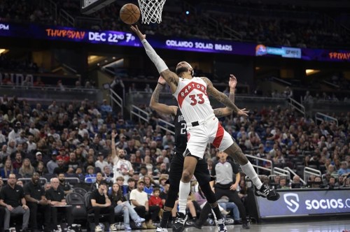 Toronto Raptors guard Gary Trent Jr. (33) goes up to shoot in front of Orlando Magic guard Markelle Fultz during the first half of an NBA basketball game, Sunday, Dec. 11, 2022, in Orlando, Fla. (AP Photo/Phelan M. Ebenhack)