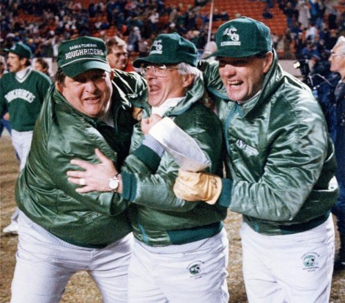 Saskatchewan Roughriders coaches Ted Heath, left to right, John Gregory and Ron Cherkus get into the winning spirit as they march across the field after defeating the Edmonton Eskimos for the Western Final in Edmonton on Sunday, November 19, 1989. Former CFL coach John Gregory, who guided the Saskatchewan Roughriders to a Grey Cup victory in 1989, has died. He was 84. THE CANADIAN PRESS/Dave Buston