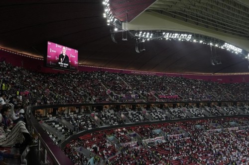 A tribute to journalist Grant Wahl is shown on a screen before the World Cup quarterfinal soccer match between England and France, at the Al Bayt Stadium in Al Khor, Qatar, Saturday, Dec. 10, 2022. Wahl, one of the most well-known soccer writers in the United States, died early Saturday Dec. 10, 2022 while covering the World Cup match between Argentina and the Netherlands. (AP Photo/Hassan Ammar)