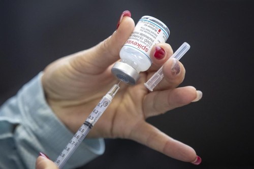 A person draws out a vaccine in Kingston, Ont., on Sunday Jan. 2, 2022. A study from the C.D. Howe Institute estimates Canada would have lost $156 billion in economic activity in 2021 had COVID-19 vaccines been rolled out six months later than they were. THE CANADIAN PRESS/Lars Hagberg