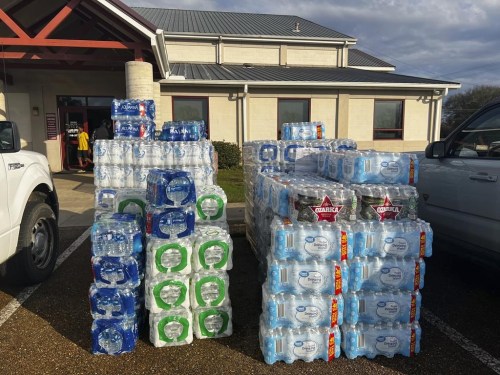 Cases of water and other supplies are available at the Farmerville Recreation Center in Farmerville, La., Wednesday, Dec. 14, 2022, after a destructive storm system caused severe weather in the area. (AP Photo/Stephen Smith)