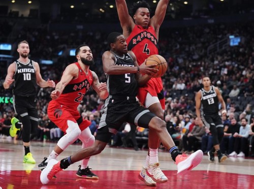 Sacramento Kings guard De'Aaron Fox (5) drives as Toronto Raptors guard Fred VanVleet (23) and forward Scottie Barnes (4) defend during second half NBA basketball action in Toronto on Wednesday, December 14, 2022. THE CANADIAN PRESS/Nathan Denette