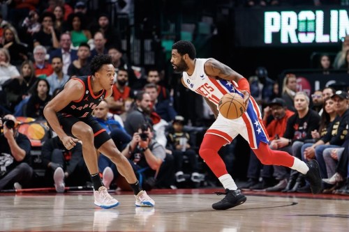 Brooklyn Nets guard Kyrie Irving (11) dribbles against Toronto Raptors forward Scottie Barnes (4) during the first half of their NBA game in Toronto on Friday, Dec. 16, 2022. THE CANADIAN PRESS/Cole Burston