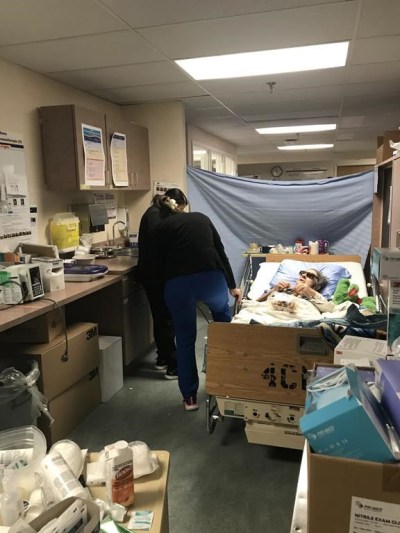 Irene MacNeill, 88, of Barnesville, N.B., lays in bed as nurses move the bed to access an electrical outlet after she was placed in a supply room at an over capacity Saint John Regional Hospital, in Saint John, N.B., in a Thursday, Dec. 15, 2022, handout photo. MacNeill, who broke her arm in a fall and bruised her hip, went to hospital but hasn't been able to access a nursing home during her recovery. Nurses set up an improvised bed sheet for her privacy and her daughter provided her with dark glasses to cope with the overhead lights that couldn't be turned off. THE CANADIAN PRESS/HO-Karen Totten, *MANDATORY CREDIT*