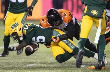 B.C. Lions' Mathieu Betts (90) tackles Edmonton Elks' Christian Saulsberry (25) during second half CFL action in Edmonton, Alta., on Friday October 21, 2022. THE CANADIAN PRESS/Jason Franson.