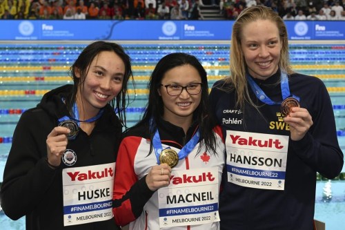 Maggie Mac Neil of Canada, centre Torri Huske of the U.S., left, and Louise Hansson of Sweden display their medals after the women's 100m butterfly final during the world swimming short course championships in Melbourne, Australia, Sunday, Dec. 18, 2022. Mac Neil won gold, Huske took silver and Hansson the bronze. THE CANADIAN PRESS/AP/Asanka Brendon Ratnayake