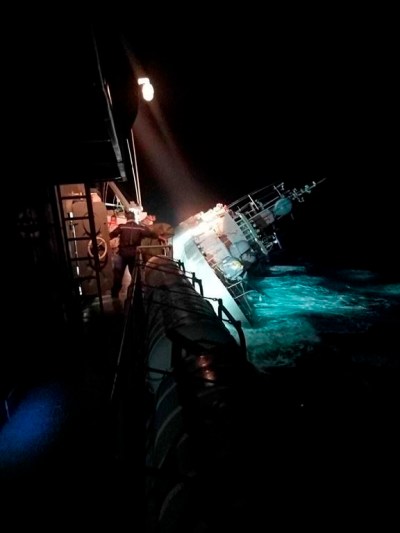 In this photo provided by the Royal Thai Navy, the HTMS Sukhothai corvette leans on its side off the coast of Prachuap Khiri Khan province, Thailand on Sunday, Dec. 18, 2022. The Thai navy ship sunk in the Gulf of Thailand and ships and helicopters were working Monday to rescue sailors from the water. (Royal Thai Navy via AP)