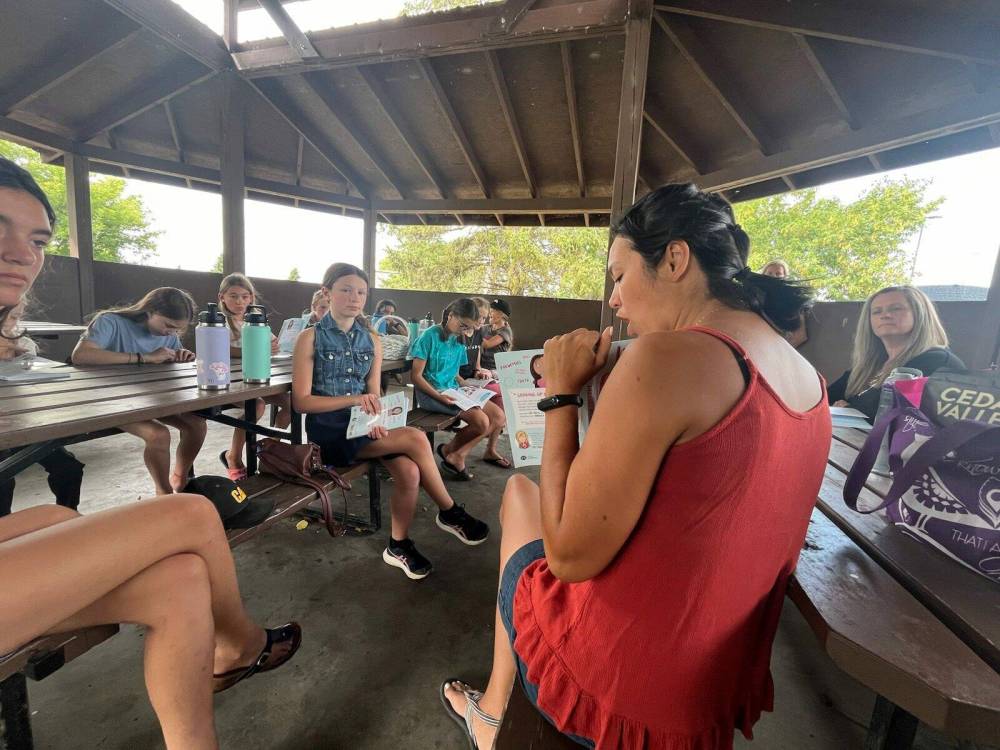Raquel Driedger leads the book club outside Brandon’s Discovery Centre. (Connor McDowell/The Brandon Sun)