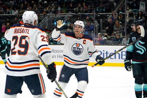 Edmonton Oilers’ Connor McDavid reacts to a goal with Leon Draisaitl (29) against the Seattle Kraken in 2021. This season, the pair are responsible for over 40% of the team’s total scoring output. (AP Photo/Elaine Thompson)