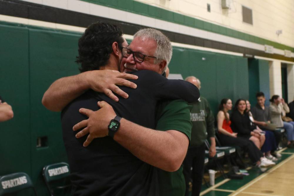 Don Thomson hugs his son Jacob as more than 70 alumni, coaches, friends and family surprised the retiring athletic director at the Neelin Spartans awards night on Tuesday. (Thomas Friesen/The Brandon Sun)