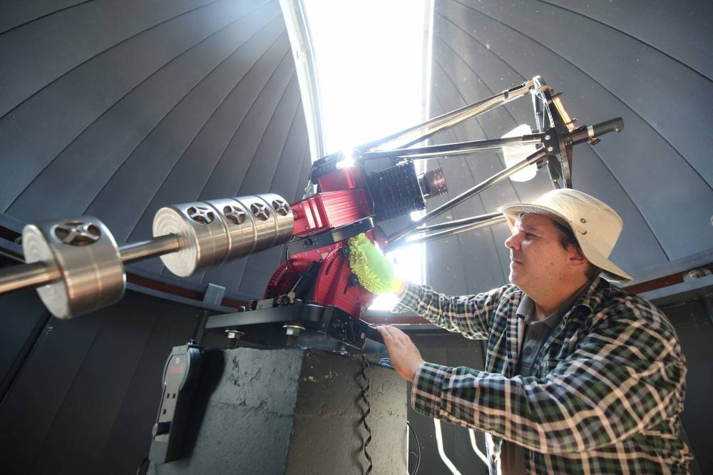 Prof. Tyler Foster with Brandon University’s Department of Physics and Astronomy cleans the BU Observatory telescope at the top of the John R. Brodie Science Centre on Wednesday morning. (Matt Goerzen/The Brandon Sun)