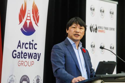 LEFT: Chris Avery of Arctic Gateway Group speaks during the Manitoba Chambers of Commerce breakfast event in Winnipeg on Wednesday morning. (Mike Deal/Winnipeg Free Press) RIGHT: The MV Aujaq, a heavy-cargo ship from Montreal, sits at the Port of Churchill in a 2019 photo. (Dylan Robertson/Winnipeg Free Press files)