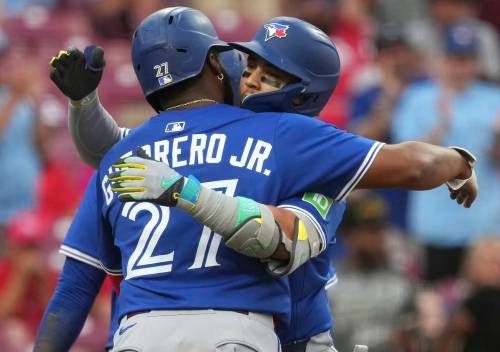 Toronto Blue Jays Bo Bichette and Vladimir Guerrero Jr. hug in a game against the Cincinnati Reds in September in Cincinnati. (The Associated Press files)