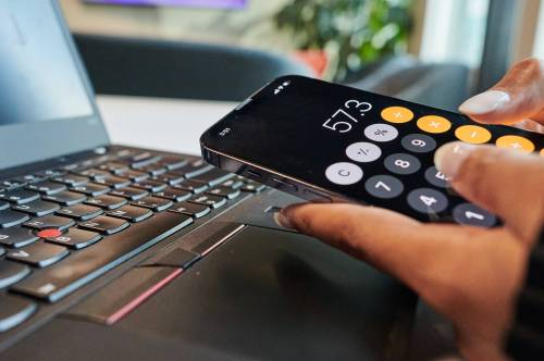 A person uses the calculator app on their phone. (The Canadian Press files)