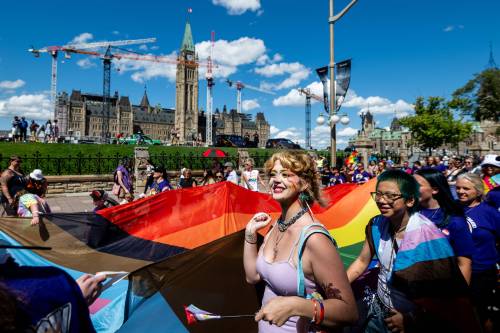 Capital Pride Parade attendees representing the Ottawa Carleton District School Board (OCDSB) hold a large rainbow flag near Parliament Hill during the Capital Pride Parade in Ottawa, in August 2025. (The Canadian Press files)