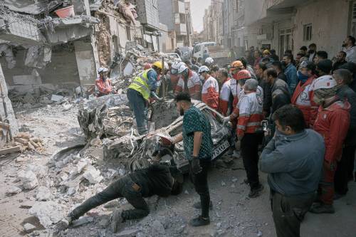 First responders inspect a destroyed car at the site of a residential building hit in an overnight strike during the U.S.-Israeli military campaign in Tabriz, East Azerbaijan Province, northwestern Iran, on Tuesday. (The Associated Press)