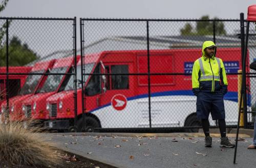 A striking Canada Post worker stands at a picket line outside a delivery depot, in Burnaby, B.C., in September 2025. (The Canadian Press files)