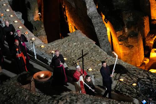 Pope Leo XIV carries a lightweight, 1.5-metre wooden cross during the Via Crucis, the torchlit Good Friday Stations of the Cross procession at the Colosseum in Rome on Friday. (The Associated Press)