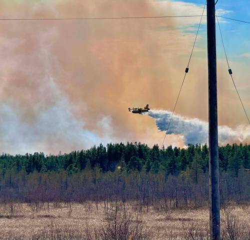 A water bomber fights a wildfire southwest of Chemawawin Cree Nation on Tuesday. (Photo by Leslie Arrow)
