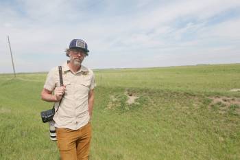 Tim Smith, The Brandon Sun&rsquo;s only photojournalist, is seen outside a fox den near Brandon in June. Smith photographed several kits and their mother at the den this spring after waiting more than three hours. He said he returns to about a dozen dens in the area every year. (Connor McDowell/The Brandon Sun)