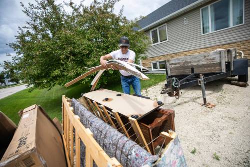 George Bird helps clear out a water-damaged basement in Stonewall on Thursday, two days after storms across Manitoba led to a massive number of property and vehicle damage claims. (Mikaela MacKenzie/Winnipeg Free Press)