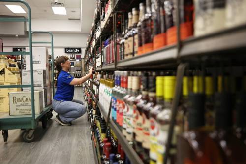 Jessica Crang with the Manitoba Liquor Mart on 10th Street and Victoria Avenue helps stock American alcohol onto shelves at the Brandon retailer in December. Provincial data shows Manitobans continue to prefer Canadian liquor even after U.S. beverages were returned to shelves during the trade dispute. (Tim Smith/The Brandon Sun files)