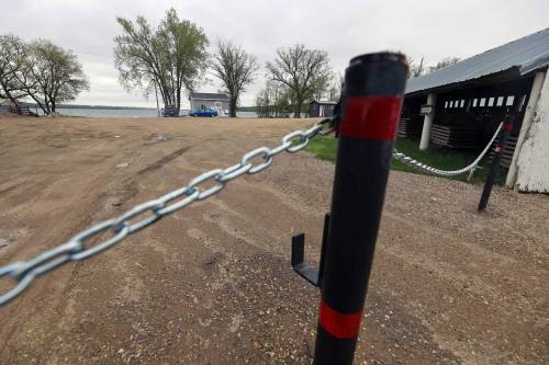 Chained gates stand in Ninette outside the boat launch onto Pelican Lake in 2025. The Rural Municipality of Prairie Lakes installed the gates as part of an effort to prevent AIS from entering the lake, and is continuing the effort this year with some adjustments following provincial government funding. (Connor McDowell/Brandon Sun)