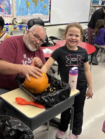 LEFT: Hands-on pumpkin carving is great fun for kids and seniors alike. RIGHT: Themed story time shared across generations with Brandon Seniors for Seniors. (Photos supplied)