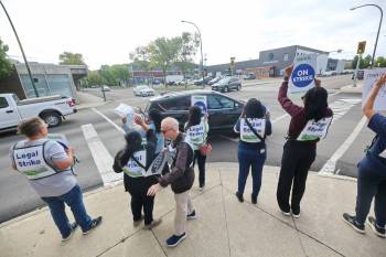 Striking Dynacare lab workers in Brandon wave to honking supporters at the busy Sixth Street and Princess Avenue intersection on Tuesday morning. They were ordered back to work after the Manitoba Labour Board halted their strike after just one day. (Matt Goerzen/The Brandon Sun)