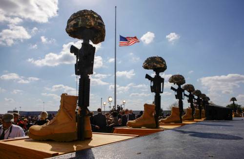 A flag at half-staff is framed by helmets, rifles and boots at Fort Hood, Texas, in November 2009, prior to a memorial for those killed at the post on Nov. 5 of that year. Maj. Nidal Malik Hasan will be executed by firing squad at Fort Hood, Texas, on Dec. 3, for fatally shooting 13 people and wounding 32. (The New York Times files)