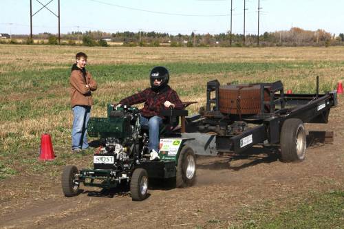A University of Saskatchewan student pulls a heavy sled using one of the 1/4-scale tractors designed by the Sled Dogs engineering team at the farm of Kenny Beauchemin near Warman, Sask. on Oct. 3. (Kevin Berger/Clark&rsquo;s Crossing Gazette)